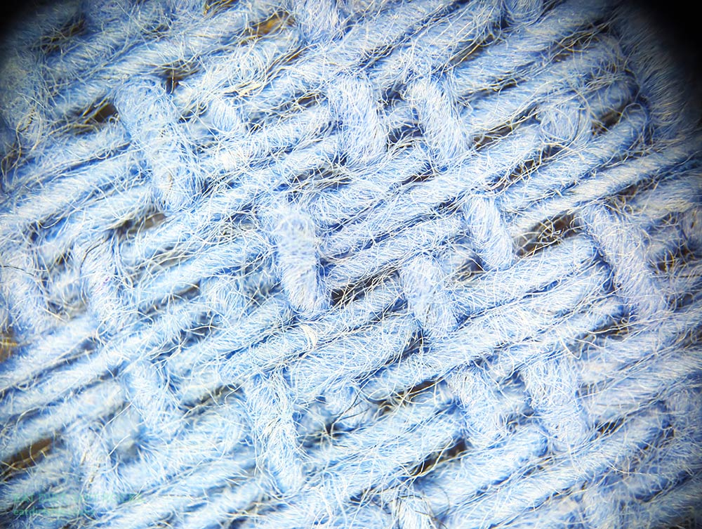 Close-up photo of the blue surgical towel, showing the color-draining effect of the phone microscope's built-in annular LED.