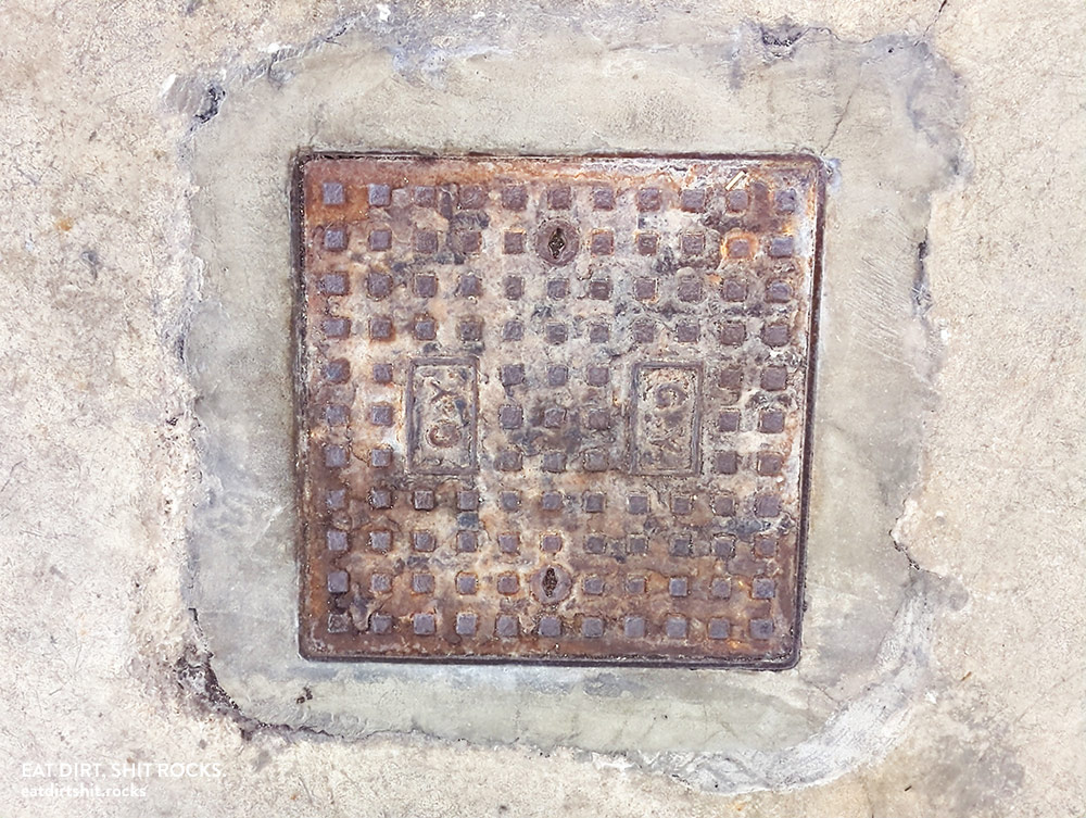 Drain cover in the same multi-level underground parking lot.