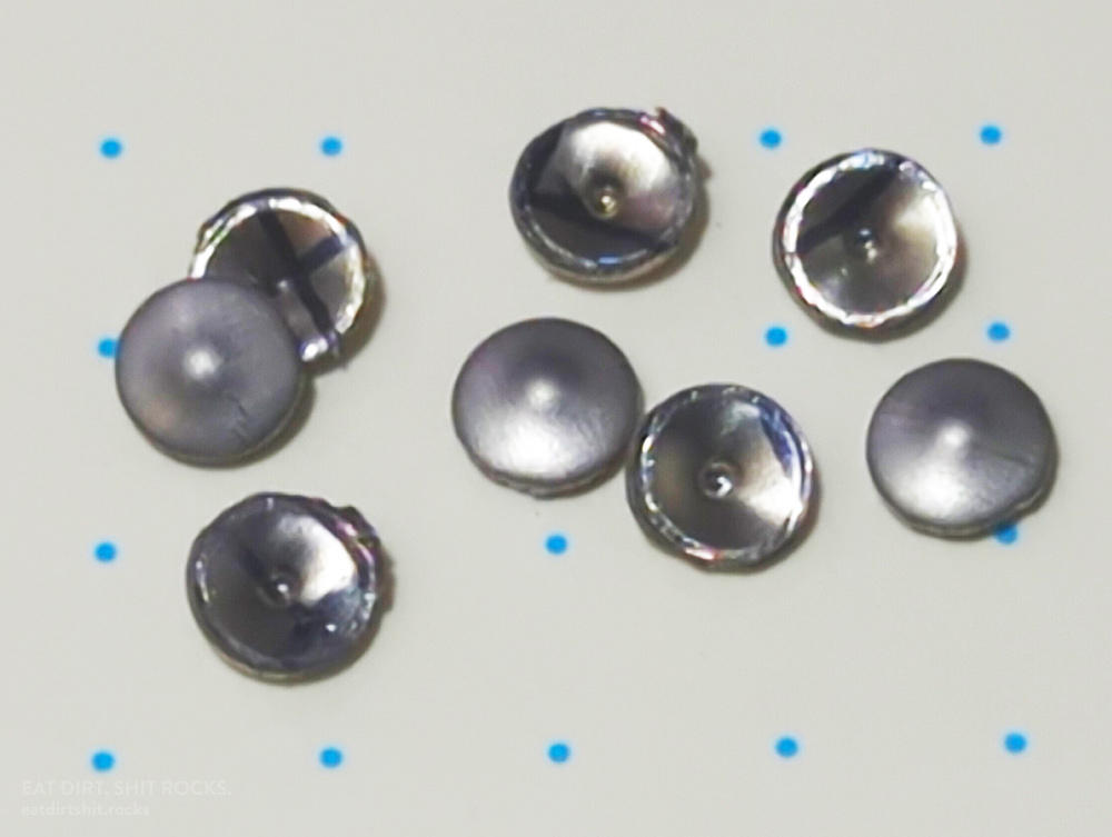 Some 304 stainless steel metal confetti, blanks produced by a manual pliers-style sheet metal punch.