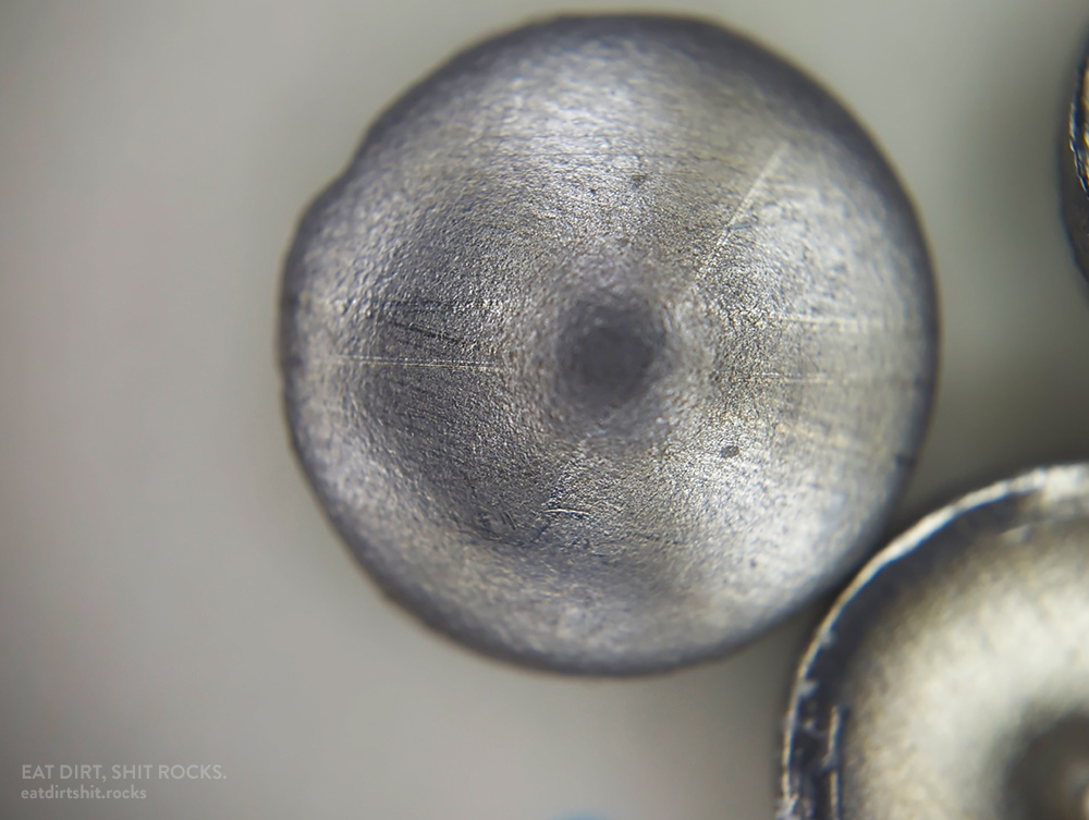 A close-up of a second convex-oriented 304 stainless steel confetto.