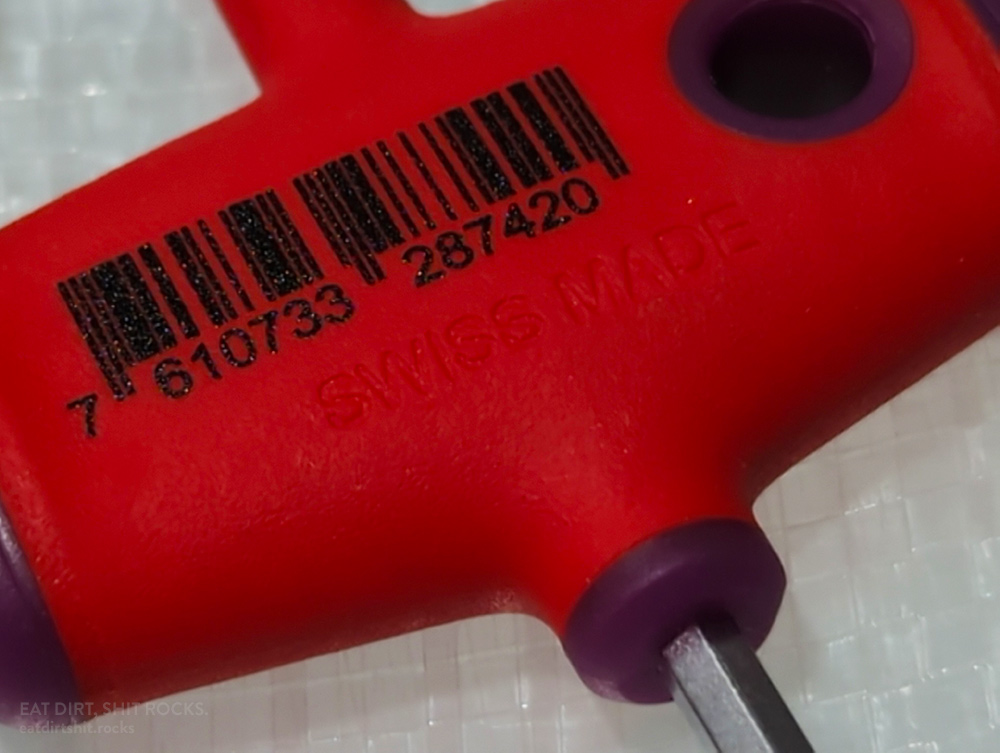 The phrase 'SWISS MADE' is debossed into the red rubber overmolding, on the reverse (non-logo) side, of each of the PB Swiss cross-handle hex drivers.
