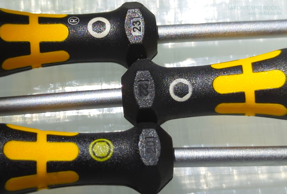 Detail view of what I suspect are production year codes molded into the hard black plastic part of the handles of three Wera 1569 nut-drivers. From top to bottom: 23, 22, and 20.